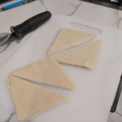 slice wonton wrappers in half w. pizza cutter